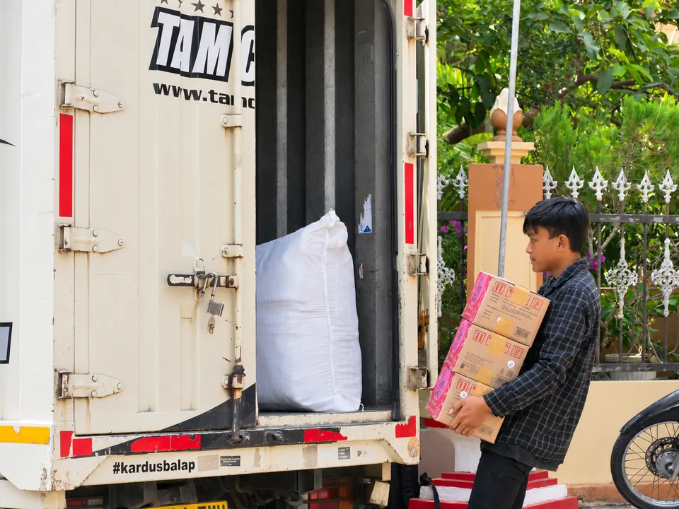 Pemuatan Barang Pesanan. Barang ditata ke kendaraan sebagai bagian dari tahap akhir penyiapan pengiriman.